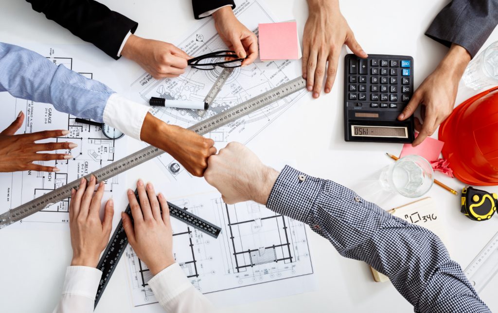 Engineers working together on blueprints